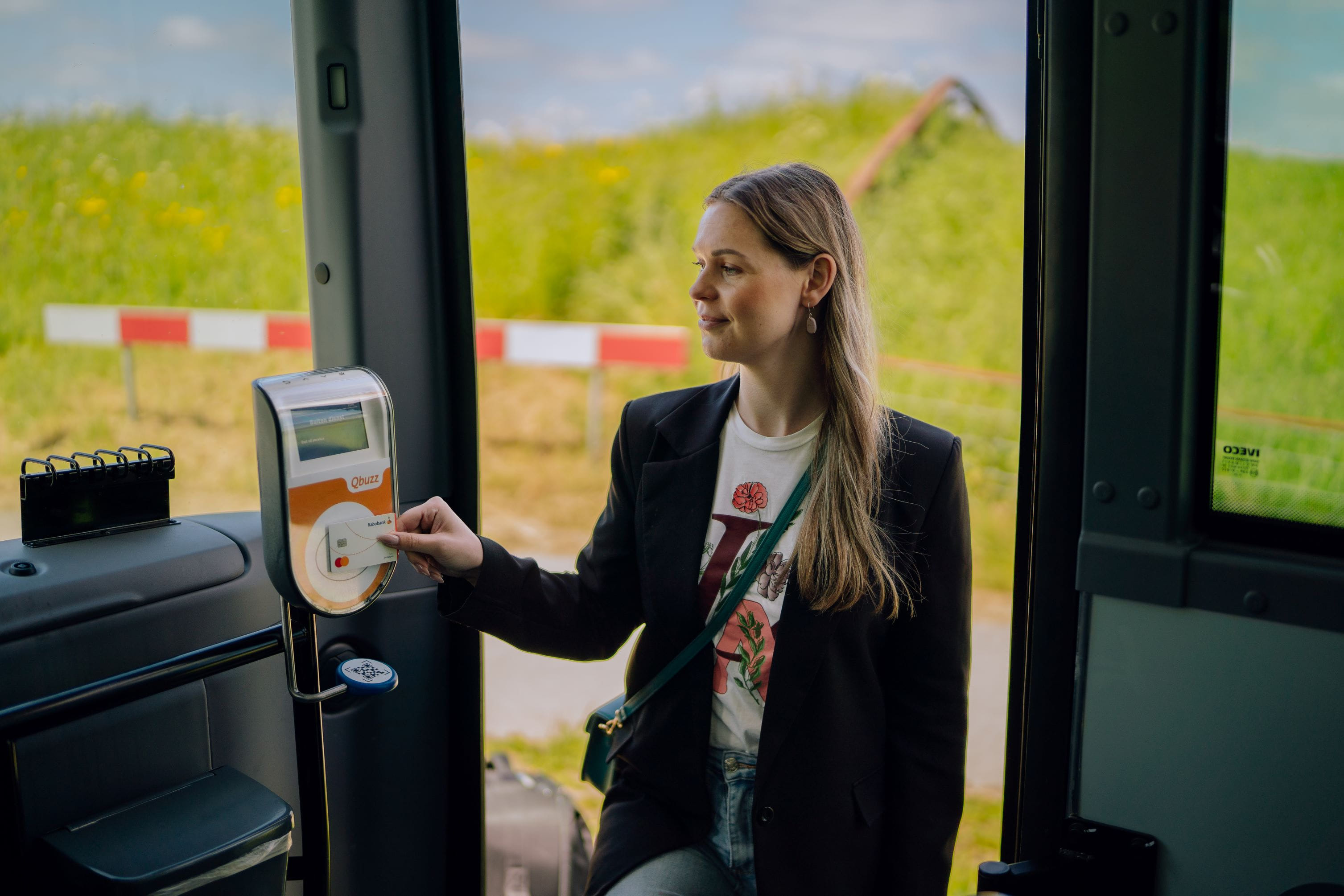 Vrouwelijke reiziger stapt in de bus en checkt in met haar bankpas